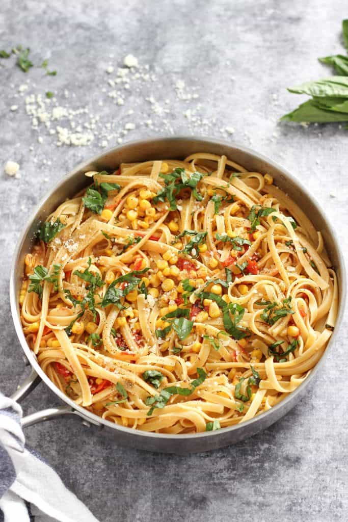 How to make the best Fettuccine with Corn and Tomatoes recipe for a delicious and light summertime meal made with fresh ingredients. #easypastarecipes #easydinnerrecipes #fettuccine #fettuccinewithcornandtomatoes #bestpastarecipes